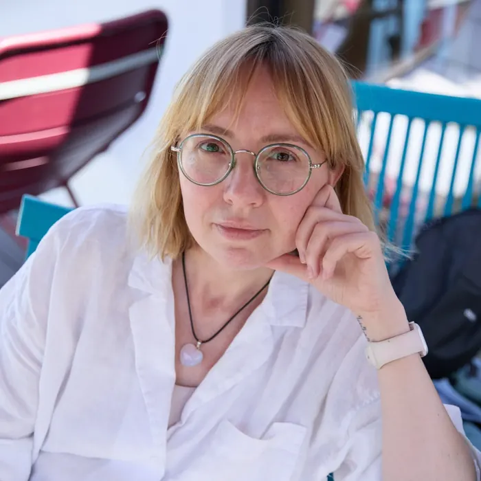 Юля Логачева в очках и белой рубашке